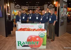 A proud team of Rainier Fruit in front of a customizable bin. Customers can choose the graphics.